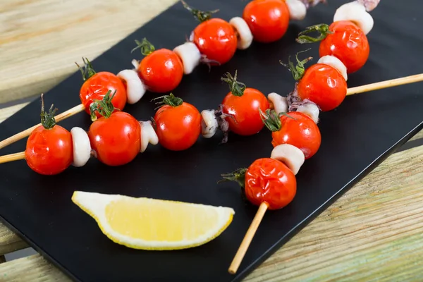 Spieße mit Mini-Tintenfisch und Tomaten — Stockfoto