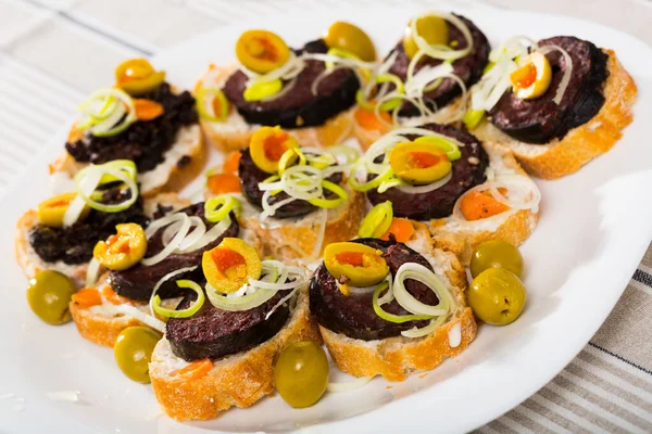 Canape-Gericht aus Blutwurst mit Oliven, Zwiebeln und Brot — Stockfoto