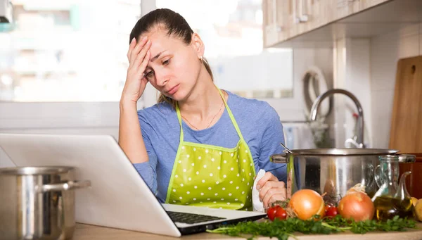 Frustrated woman looking for recipe — 图库照片