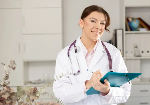 Жінка-лікар стоїть з документами в клініці — стокове фото