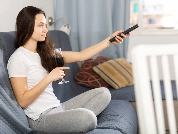 Vrouw ontspannen 's avonds met een glas rode wijn op de bank — Stockfoto