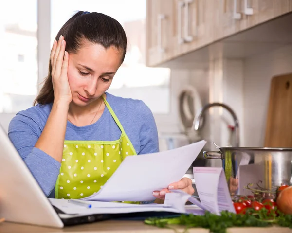 Trött ung kvinna läsa recept i köket — Stockfoto