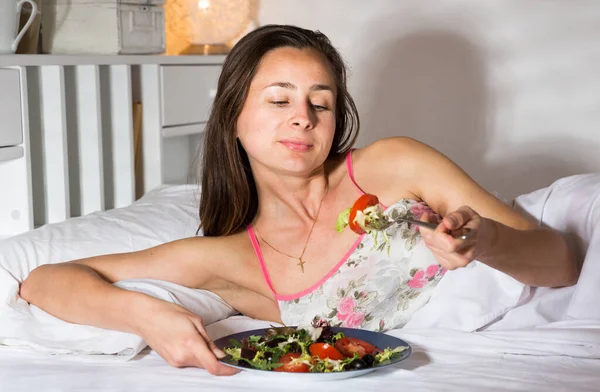 Porträtt av dam äta grönsakssallad i sängen hemma — Stockfoto
