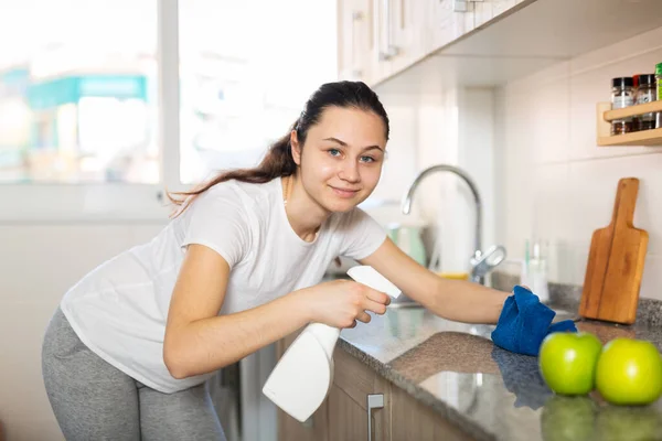 Дружелюбная женщина с тряпичной уборкой кухни дома — стоковое фото