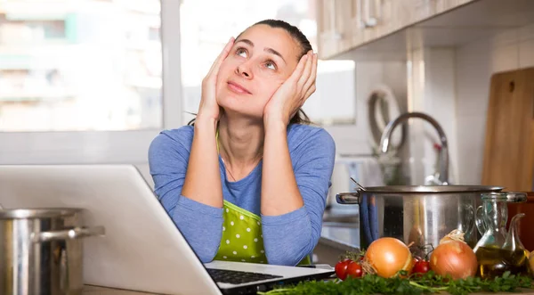 Verontrustende jonge vrouw het lezen van recept op laptop scherm — Stockfoto