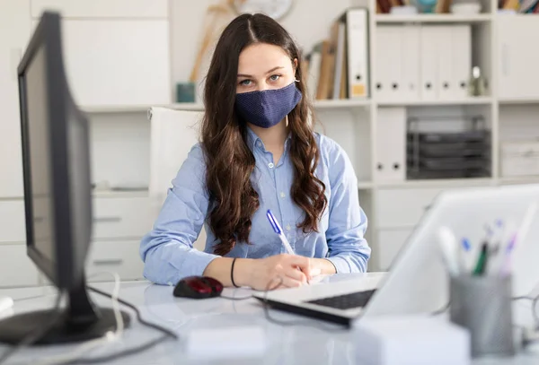 Porträtt av affärskvinna i skyddsmask i kontorsinteriör — Stockfoto