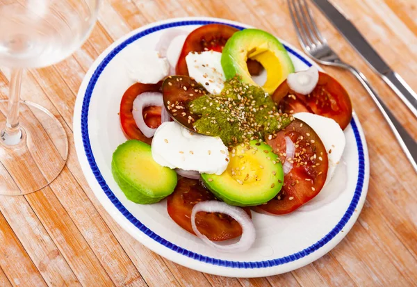 Domatesli Caprese avokado salatası, mozzarella, soğan, pesto ve susam. — Stok fotoğraf