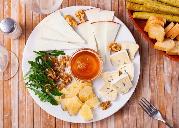 Various types of cheese on white plate — Stock Photo, Image