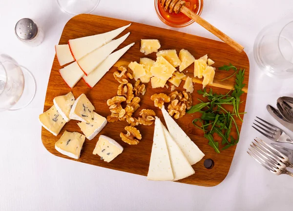 Cheese board served with honey over white background — Stock Photo, Image