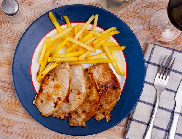 Geroosterde steaks van varkenslende met Franse gebakken aardappelen — Stockfoto