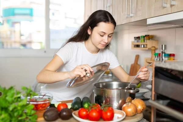 Mujer sosteniendo cuchara de cocina mientras cocina sopa —  Fotos de Stock