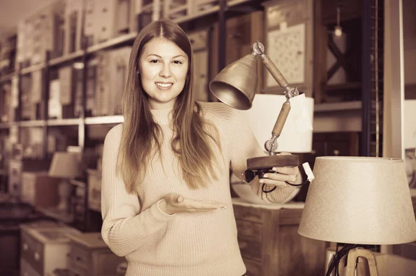 Retrato de la mujer alegre comprador elegir lámpara moderna en la tienda de muebles —  Fotos de Stock