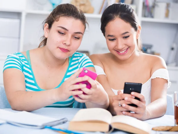 Zwei Mädchen beobachten Medien mit Smartphones — Stockfoto