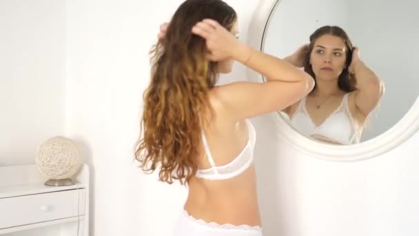 Retrato de mujer sexy joven en lencería usando espejo en el dormitorio por la mañana — Vídeo de stock
