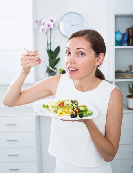 Lächelnde Frau isst Salat — Stockfoto