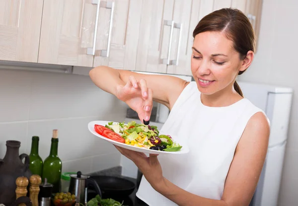 Jonge vrouw bereidt salade — Stockfoto