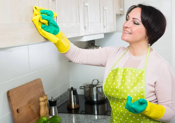 Žena v domácnosti odstraňuje skvrny ze skříní v kuchyni — Stock fotografie
