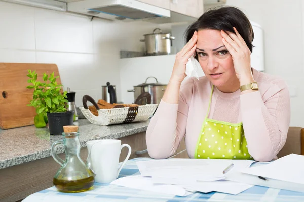 Gefrustreerde vrouw met bankdocumenten binnen — Stockfoto