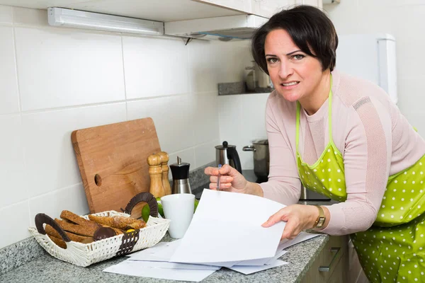 Triste dona de casa de meia idade olhando através de contas — Fotografia de Stock