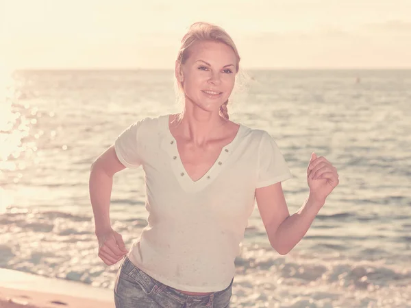 Donna in t-shirt bianca sta facendo jogging — Foto Stock