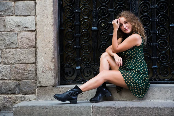 Jeune fille touristique en robe assise à l'escalier de pierre près du mur dans le centre de Barcelone — Photo