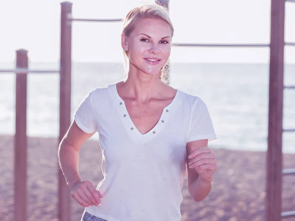 Mujer en camiseta blanca está trotando — Foto de Stock