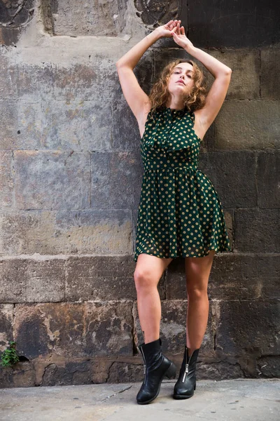 Jovem alegre de pé perto da parede de tijolo na rua em Barcelona — Fotografia de Stock