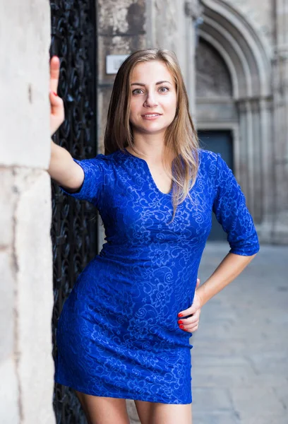 Elegantes Mädchen posiert in blauem Kleid neben schwarzer Tür — Stockfoto