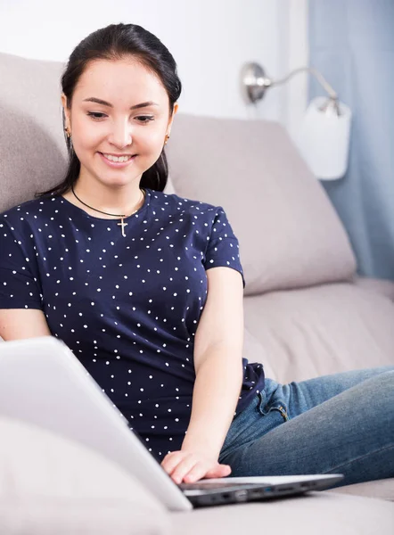 Menina sorridente no sofá com laptop — Fotografia de Stock