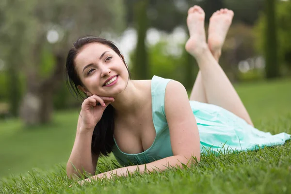 Retrato de la joven sonriente mientras está acostada al aire libre — Foto de Stock