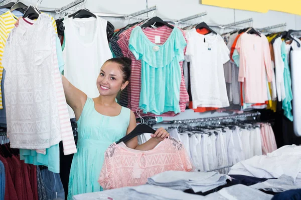 Uśmiechnięta młoda kobieta shopper wybierając nowe ubrania — Zdjęcie stockowe