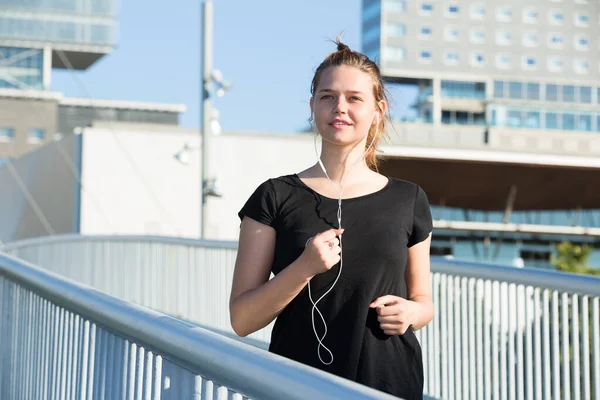 Chica Joven Corriendo Escuchando Música Puente Ciudad Mañana —  Fotos de Stock