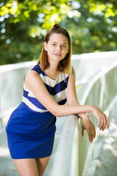 夏の都市公園の橋の上に立つ若いスタイリッシュな女の子の肖像画 — ストック写真