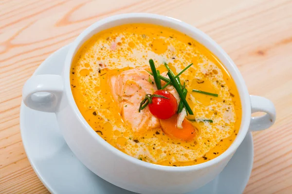 Delicious creamy salmon soup in white bowl - traditional dish of Norwegian cuisine ..