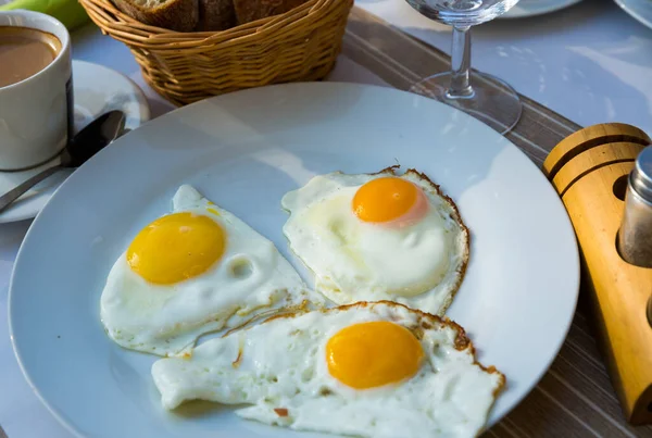 在盘子里放有煎蛋的盘子和一杯咖啡 在咖啡馆里吃早餐的图像 — 图库照片