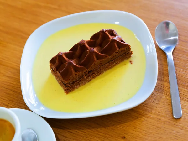 Heerlijke Chocoladetaart Met Saus Wit Bord Houten Tafel — Stockfoto