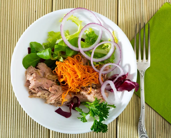 新鮮なニンジンとサラダのトップビュー 缶詰の魚 玉ねぎと白プレート上に提供される緑の混合物 — ストック写真
