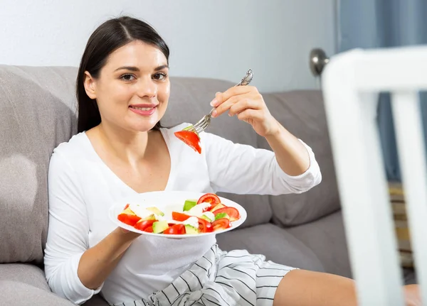 Morena Satisfeita Sentada Sofá Comendo Salada — Fotografia de Stock