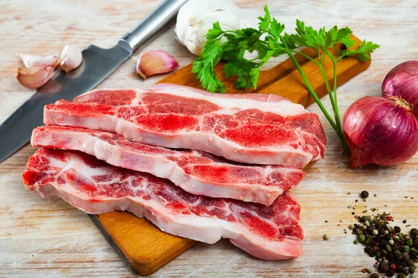 赤玉ねぎ ニンニク パセリとキッチンテーブルの上に脂肪のストレッチと生牛肉 — ストック写真