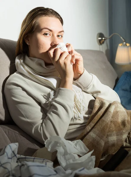 若い女性は不健康であり 自宅でナプキンと座っている — ストック写真
