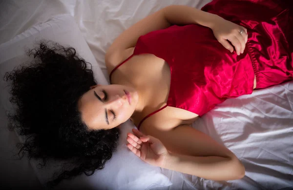 Ελκυστική Μελαχρινή Κοπέλα Κόκκινες Πιτζάμες Κοιμάται Στο Κρεβάτι — Φωτογραφία Αρχείου