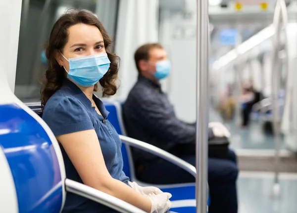 穿着一次性医疗面罩和橡胶手套坐在地铁车厢里的乐观女性的画像 大肠癌大流行期间的健康保护概念 — 图库照片