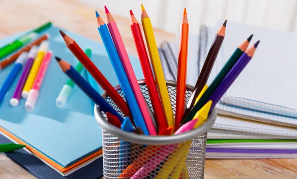 Afbeelding Van Veelkleurige Houten Potloden Bureau Met Papieren Notitieboekjes — Stockfoto