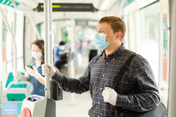 Portrait of male passenger in personal protective equipment traveling in public transport