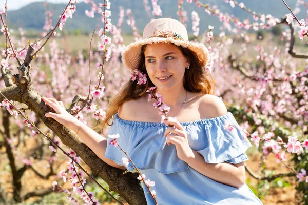 在一个桃树盛开的花园里 一个年轻微笑的女人的画像 — 图库照片