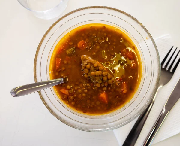 Just cooked Spanish lentil soup, sopa de lentejas, served on plate.