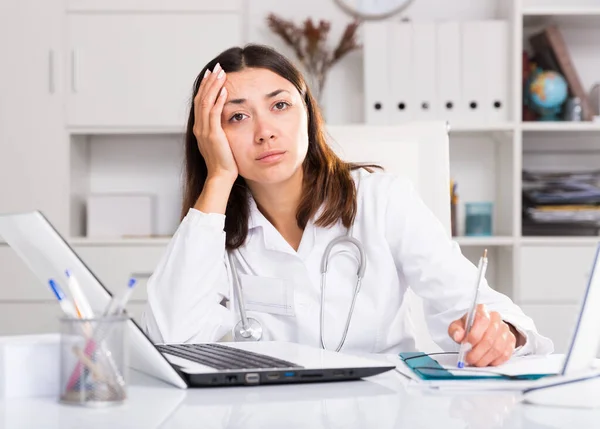 Worried Female Doctor Working Laptop Papers Her Office — Stock Photo, Image