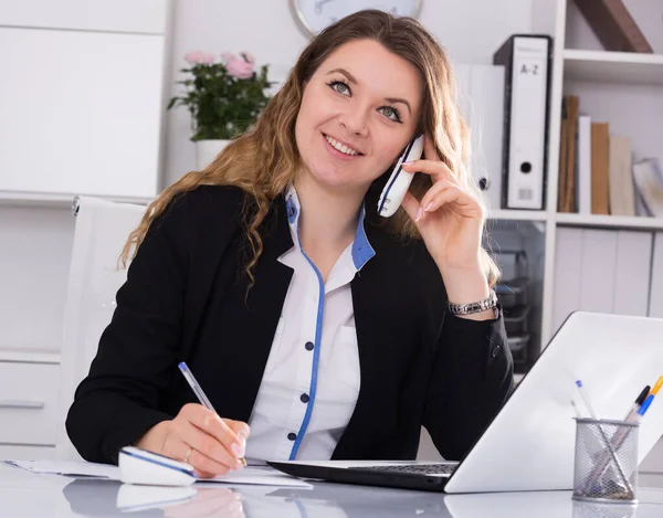 Fröhliche Businessfrau Füllt Unterlagen Aus Und Telefoniert — Stockfoto