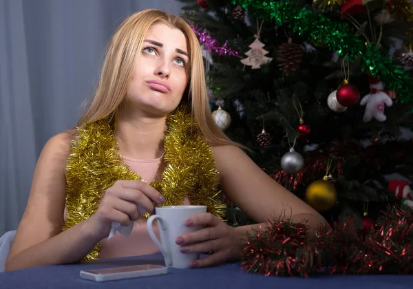 悲しい女性は家で新年の夜にお茶のカップで退屈している — ストック写真