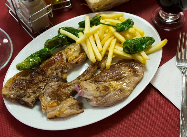 Appetizing grilled lamb with side dish of fried potatoes, jalapenos and traditional Mediterranean sauce aioli